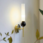 Elegant wall sconce with frosted glass shade, black marble accent, and a modern brushed gold finish.