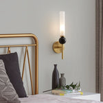 Elegant wall sconce with frosted glass shade, black marble accent, and a modern brushed gold finish.