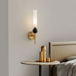 Elegant wall sconce with frosted glass shade, black marble accent, and a modern brushed gold finish.