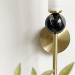 Elegant wall sconce with frosted glass shade, black marble accent, and a modern brushed gold finish.