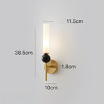 Elegant wall sconce with frosted glass shade, black marble accent, and a modern brushed gold finish.