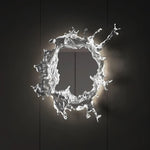 Elegant wall mirror with splash-shaped frame and integrated LED lighting, perfect for modern décor.