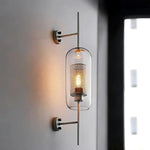 Elegant glass lantern wall sconce with a modern metal frame, perfect for ambient lighting in living rooms and bedrooms.