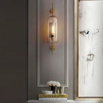 Elegant glass lantern wall sconce with a modern metal frame, perfect for ambient lighting in living rooms and bedrooms.