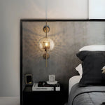 Elegant glass lantern wall sconce with a modern metal frame, perfect for ambient lighting in living rooms and bedrooms.